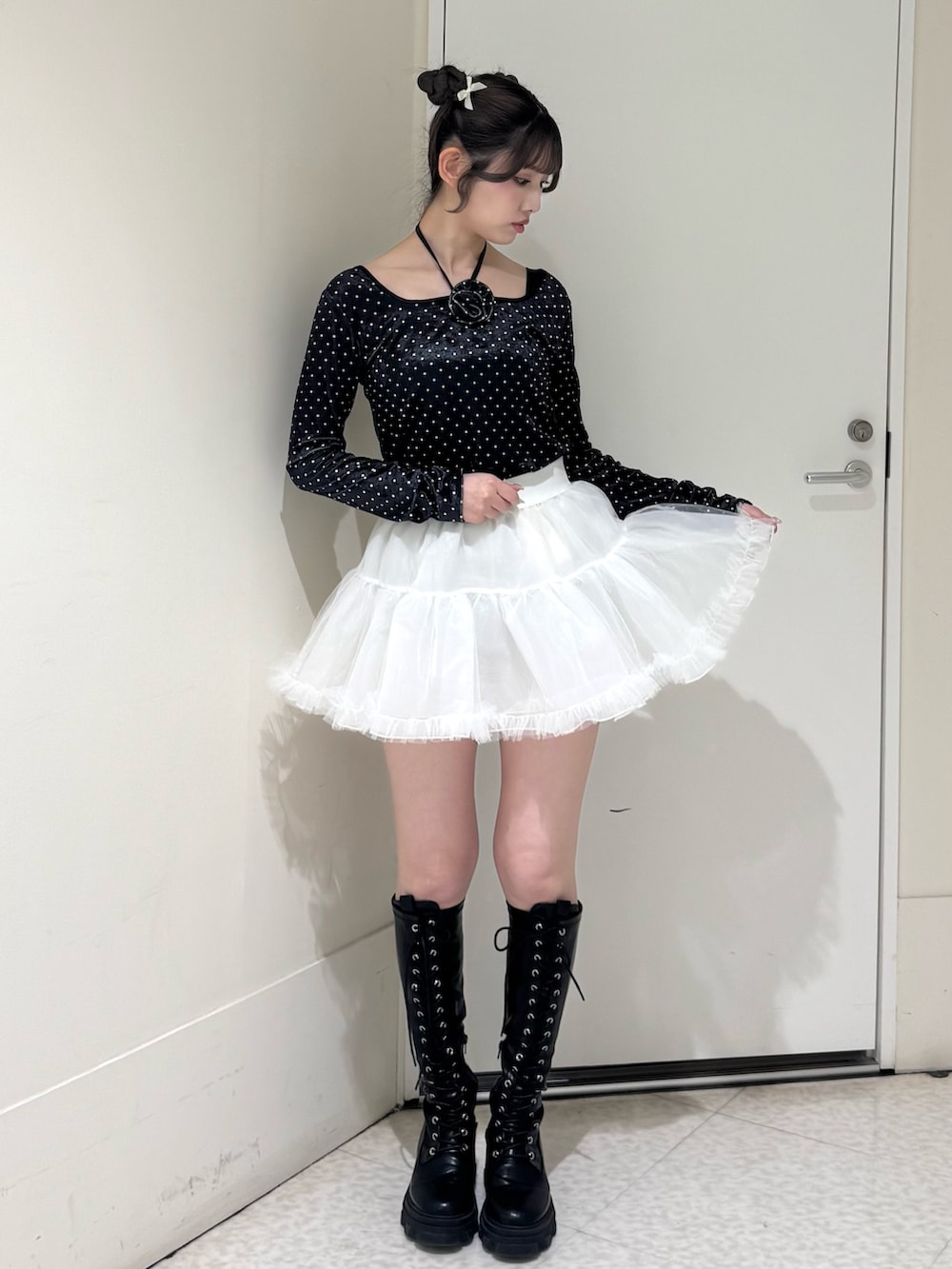 ブラック系のTシャツ/カットソー、ホワイト系のスカート、ブラック系のブーツを着用したレディースの冬コーディネートの2枚目の写真