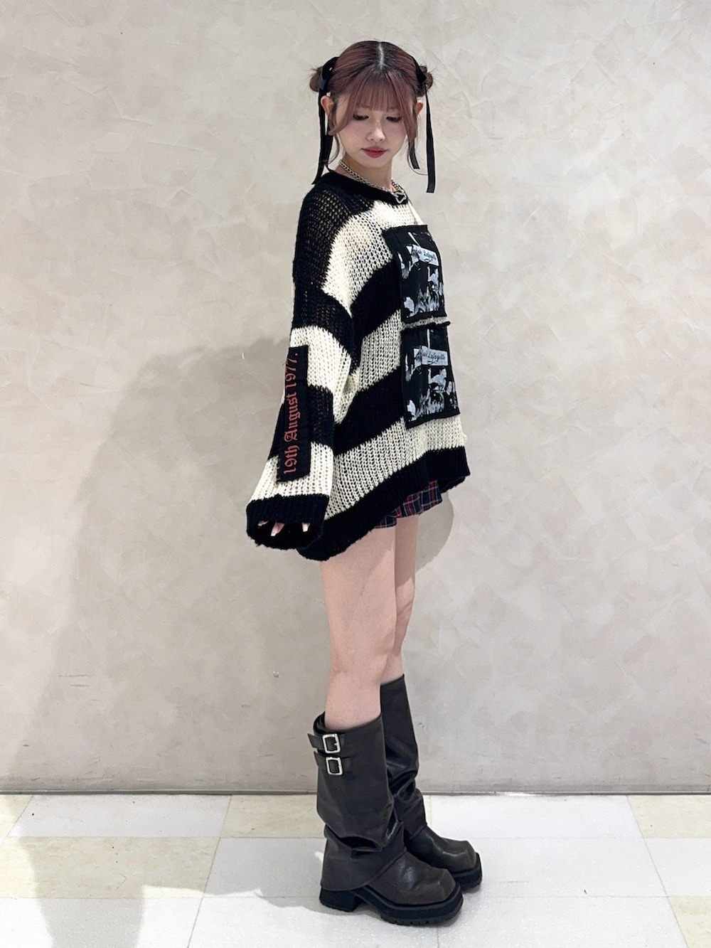 ブルー系のスカート、ブラック系のブーツ、その他のニット/セーターを着用したレディースの秋コーディネートの2枚目の写真