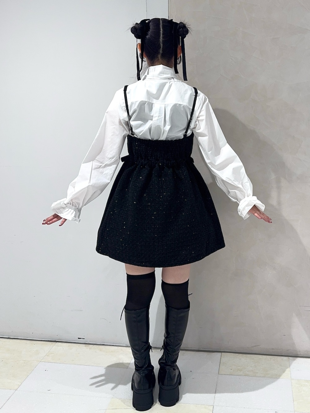 ホワイト系のシャツ/ブラウス、ブラック系のワンピース、ブラック系のブーツを着用したレディースの秋コーディネートの3枚目の写真