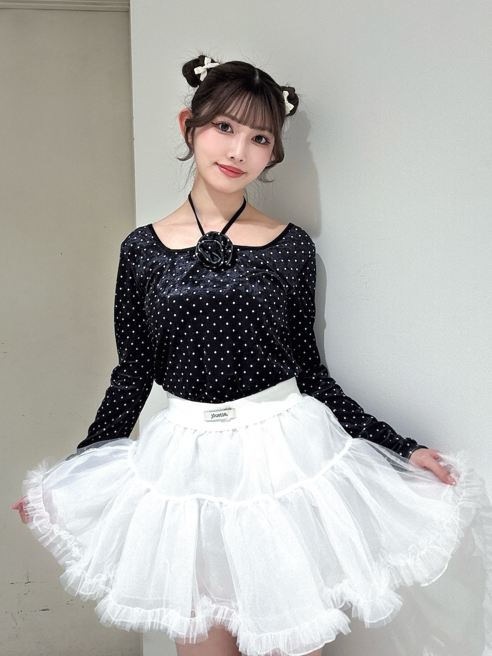 ブラック系のTシャツ/カットソー、ホワイト系のスカート、ブラック系のブーツを着用したレディースの冬コーディネートの5枚目の写真