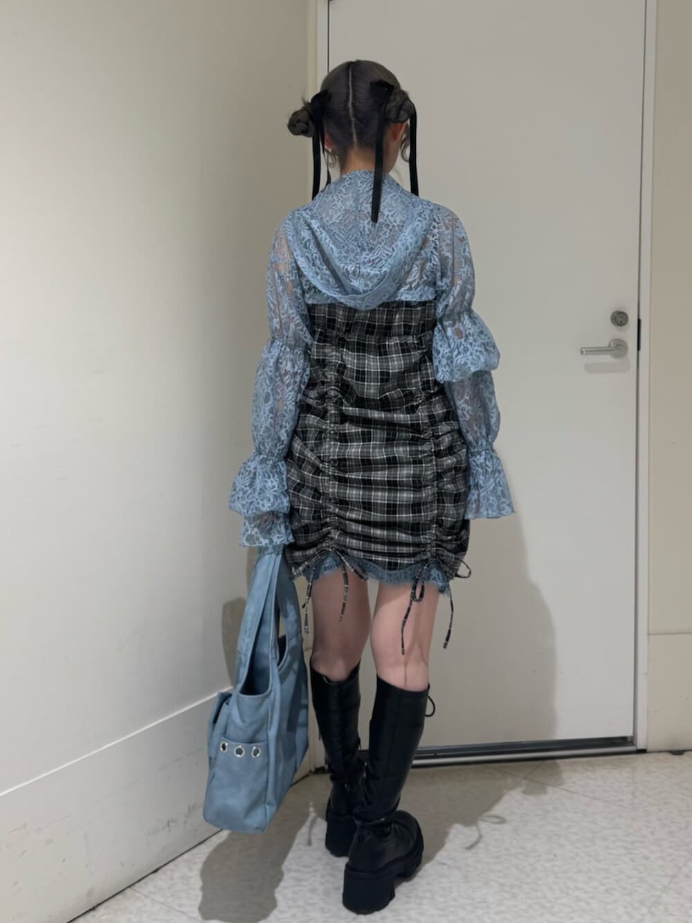 ブラック系のブーツ、ブルー系のカーディガン/ボレロ、ブルー系のトートバッグを着用したレディースの春コーディネートの4枚目の写真