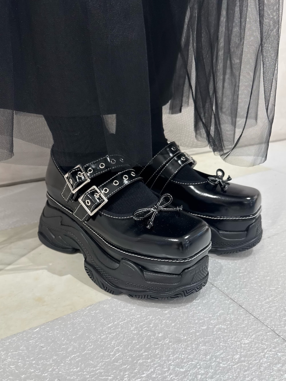 ブラック系のテーラードジャケット、ホワイト系のシャツ/ブラウス、ブラック系のネクタイを着用したレディースの秋コーディネートの7枚目の写真