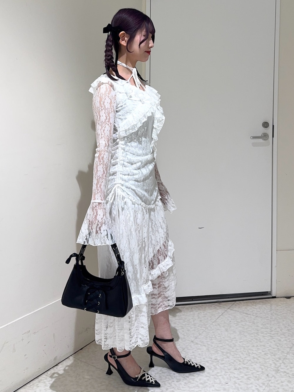 ホワイト系のワンピース、ブラック系のハンドバッグ、ブラック系のパンプスを着用したレディースの冬コーディネートの2枚目の写真