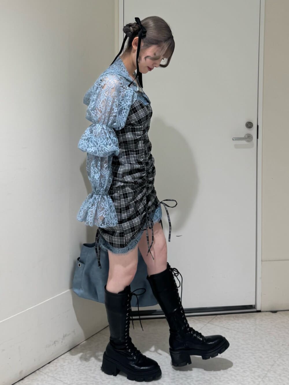 ブラック系のブーツ、ブルー系のカーディガン/ボレロ、ブルー系のトートバッグを着用したレディースの春コーディネートの3枚目の写真