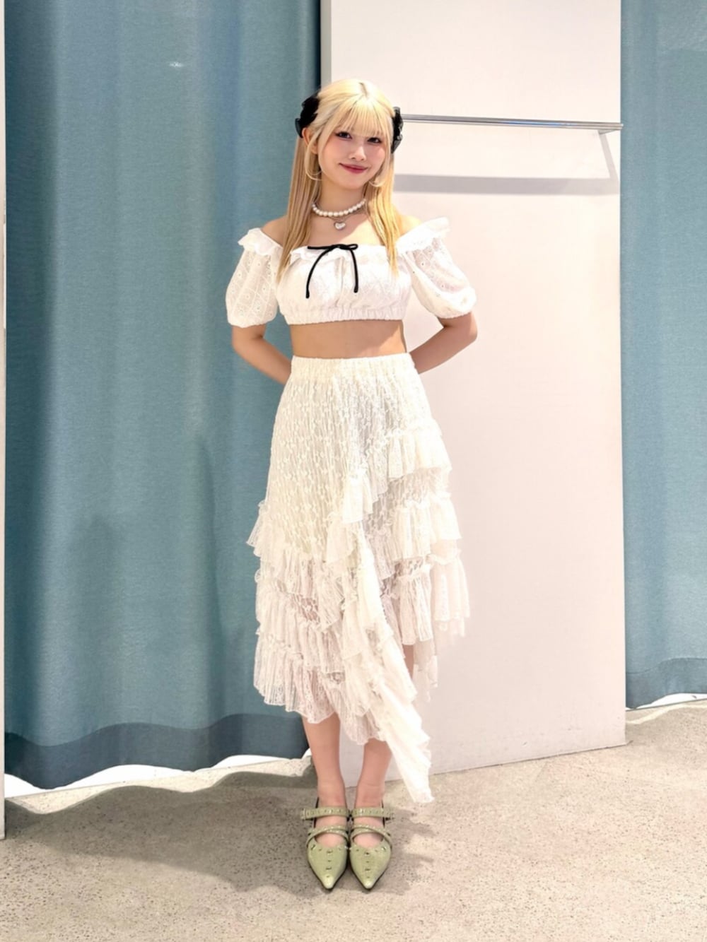 ホワイト系のスカート、グリーン系のパンプス、ホワイト系の水着を着用したレディースの夏コーディネートの2枚目の写真