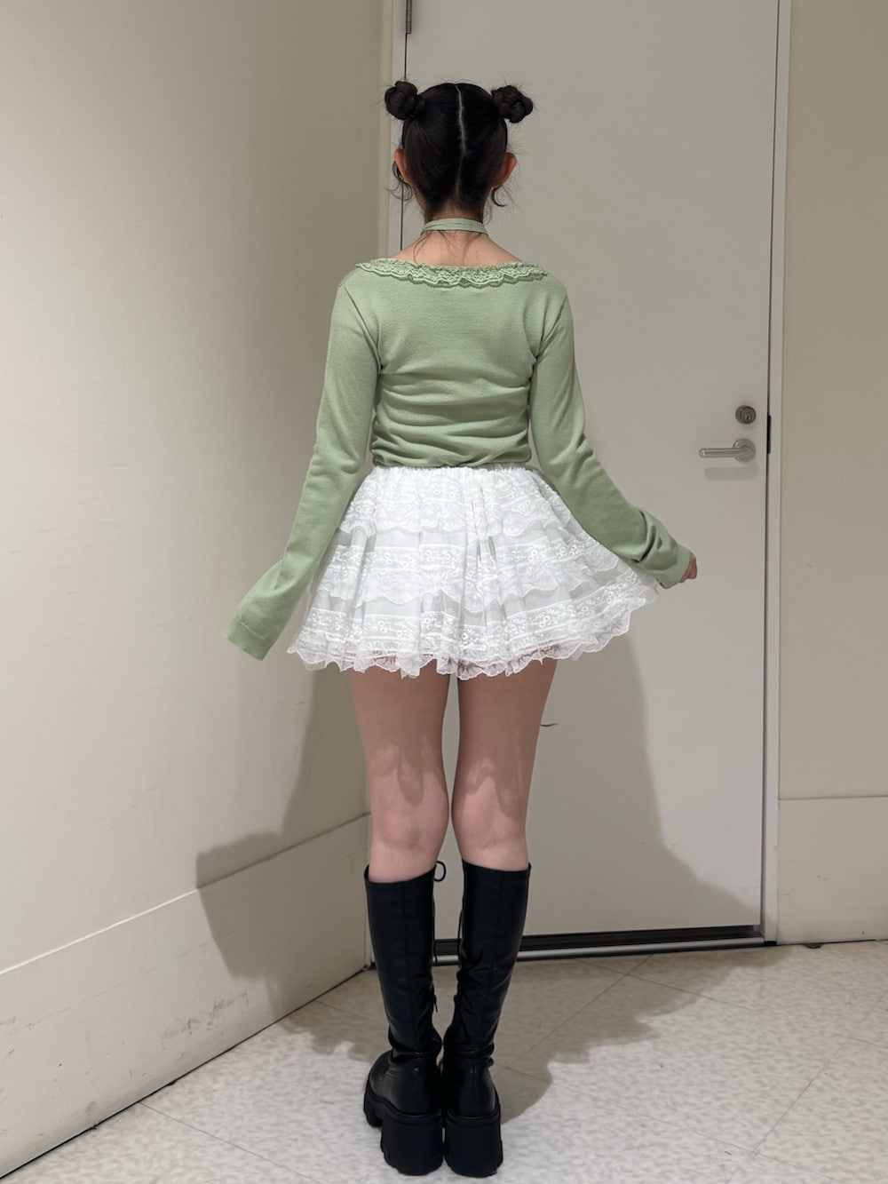 グリーン系のニット/セーター、ホワイト系のその他パンツ、ブラック系のブーツを着用したレディースの冬コーディネートの3枚目の写真