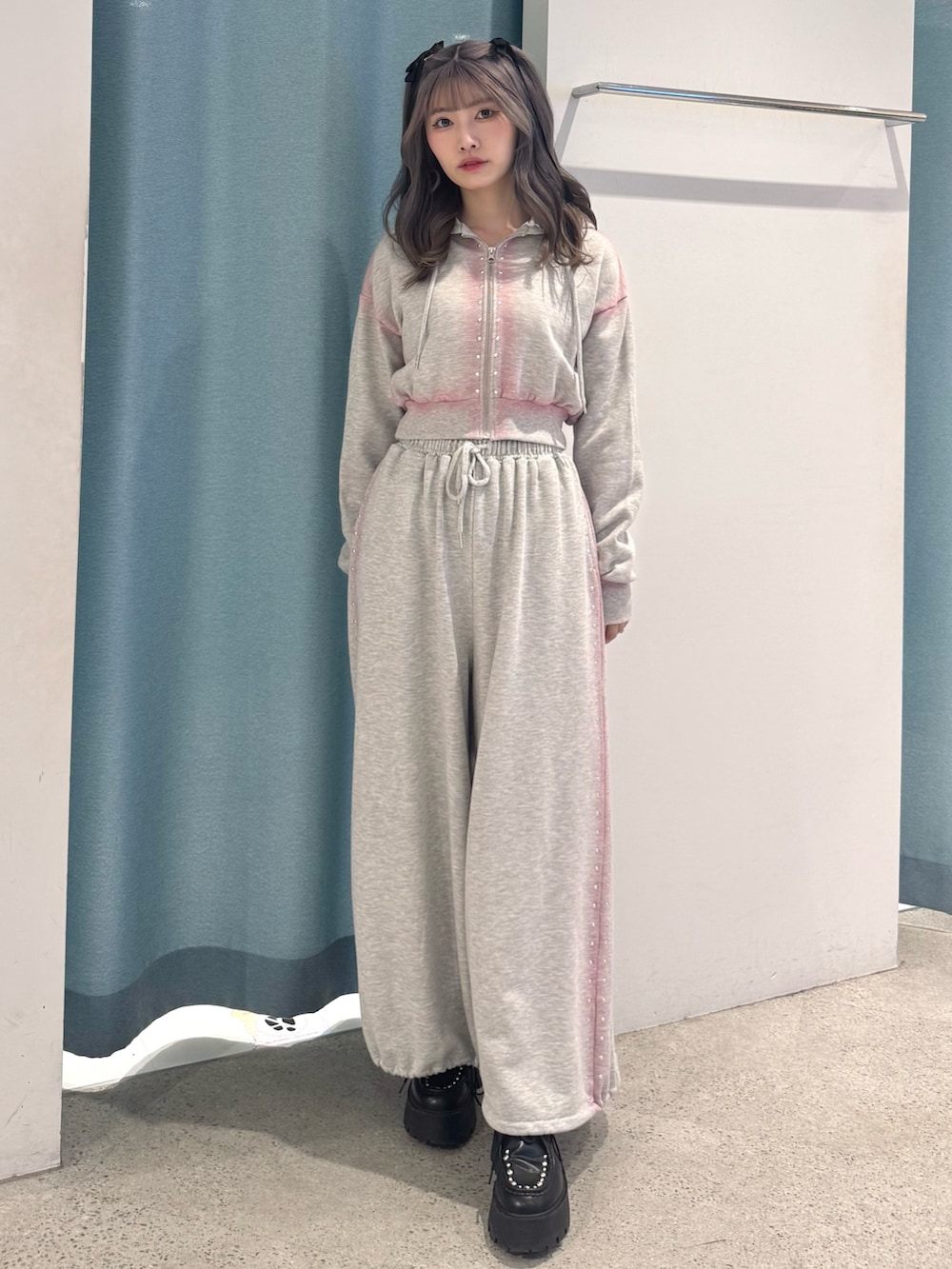 グレー系のパーカー、グレー系のスウェットパンツ、ブラック系のローファーを着用したレディースの春コーディネートの2枚目の写真