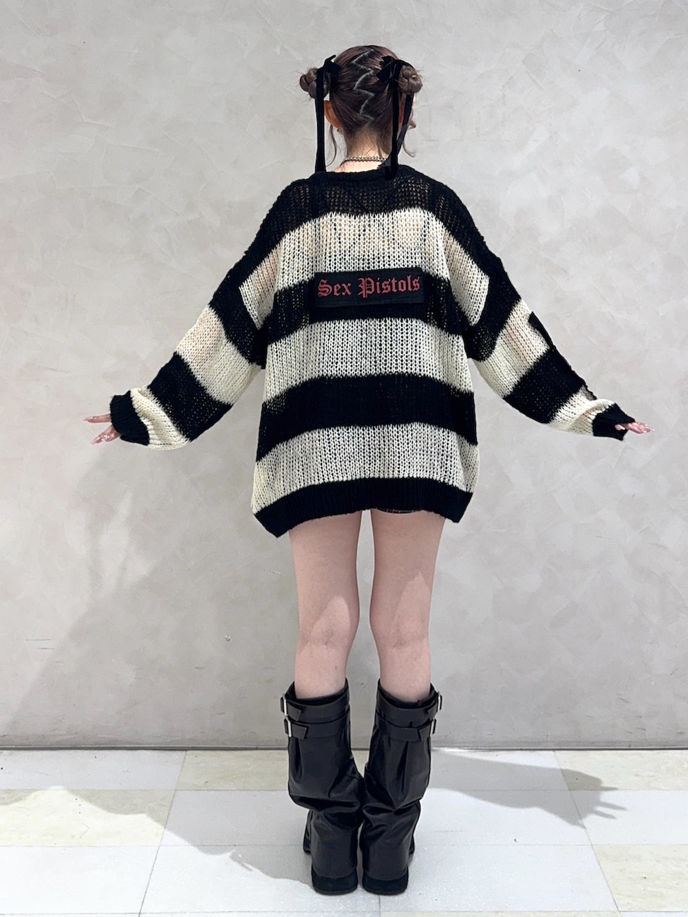 ブルー系のスカート、ブラック系のブーツ、その他のニット/セーターを着用したレディースの秋コーディネートの3枚目の写真