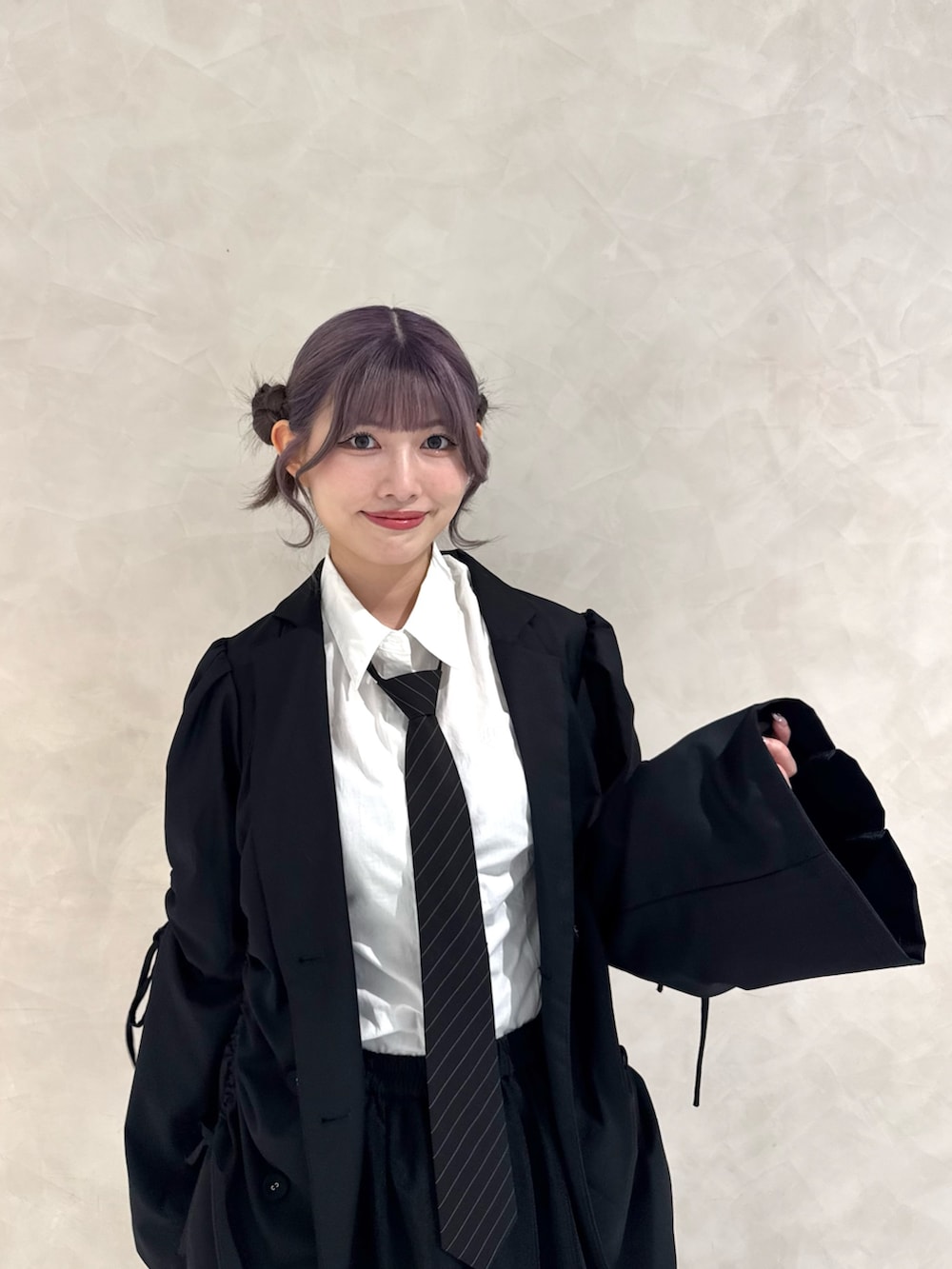 ブラック系のテーラードジャケット、ホワイト系のシャツ/ブラウス、ブラック系のネクタイを着用したレディースの秋コーディネートの4枚目の写真