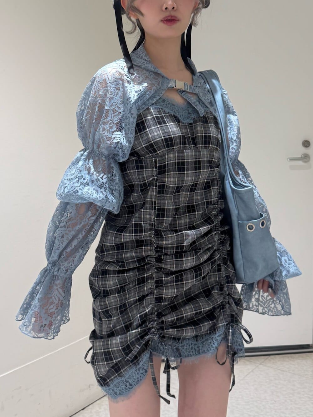 ブラック系のブーツ、ブルー系のカーディガン/ボレロ、ブルー系のトートバッグを着用したレディースの春コーディネートの5枚目の写真