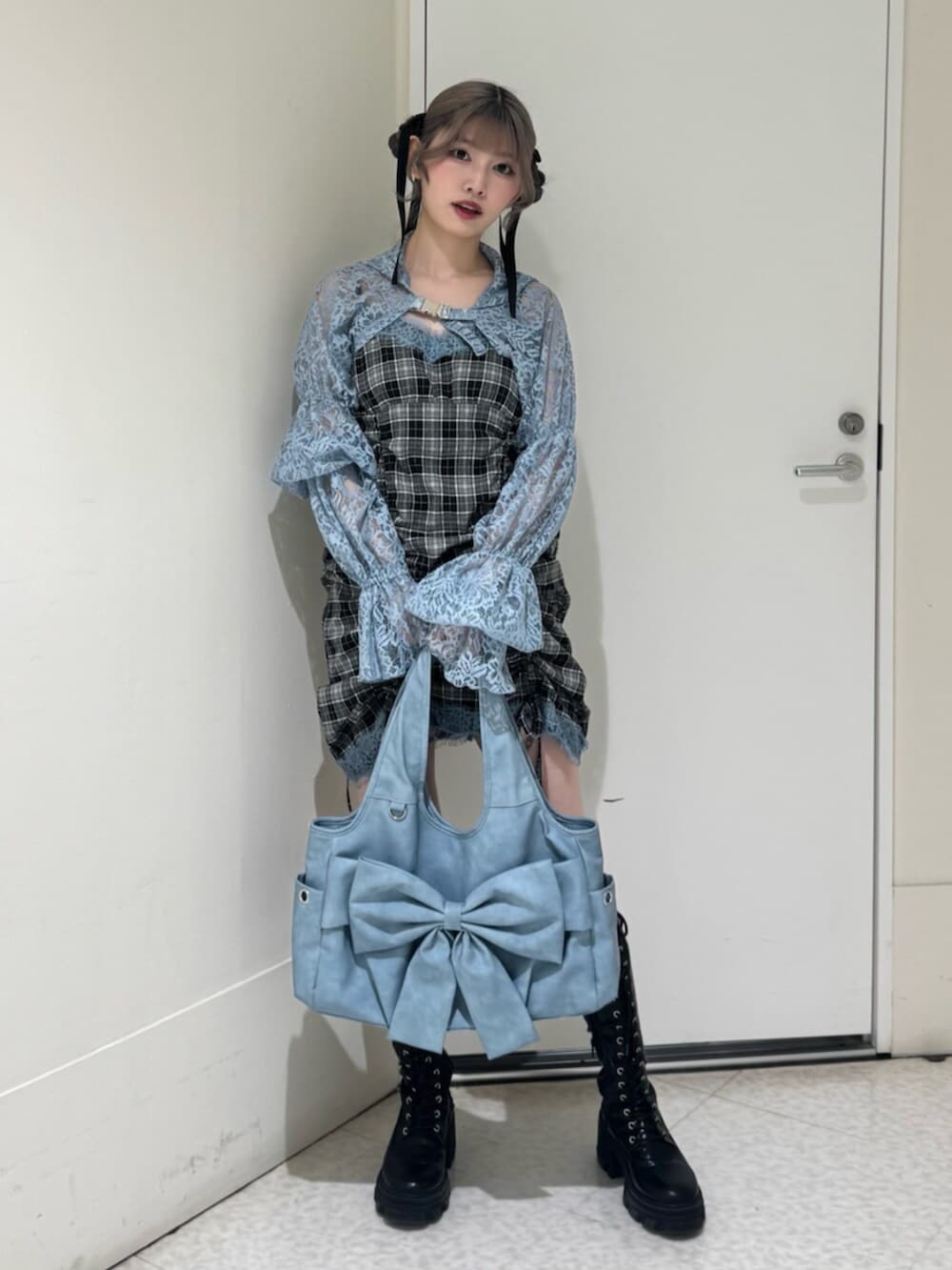 ブラック系のブーツ、ブルー系のカーディガン/ボレロ、ブルー系のトートバッグを着用したレディースの春コーディネートの2枚目の写真