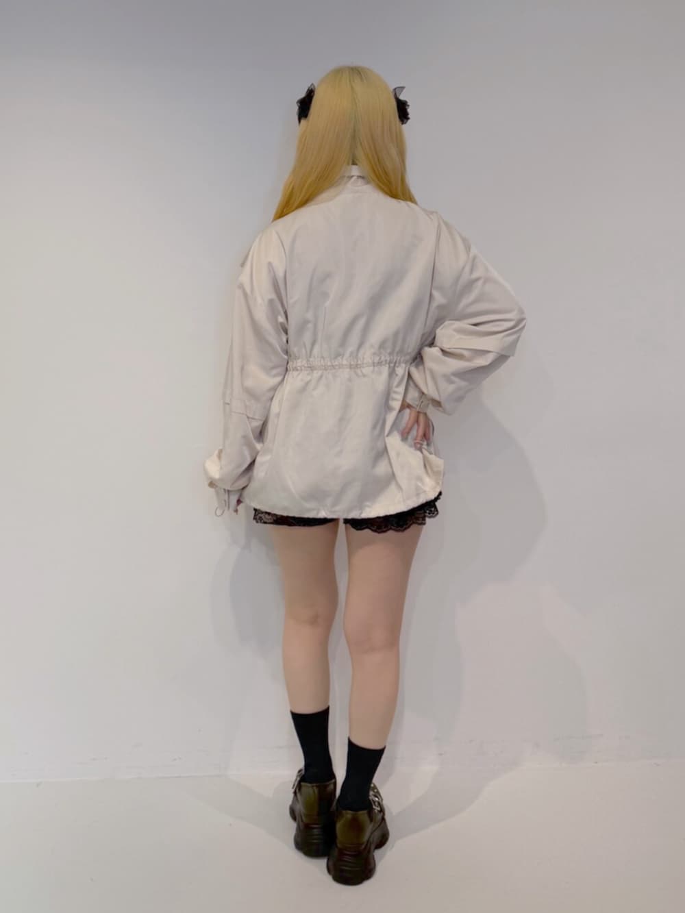 グリーン系のサンダル、ブラック系のその他パンツ、ホワイト系のブルゾンを着用したレディースの夏コーディネートの4枚目の写真