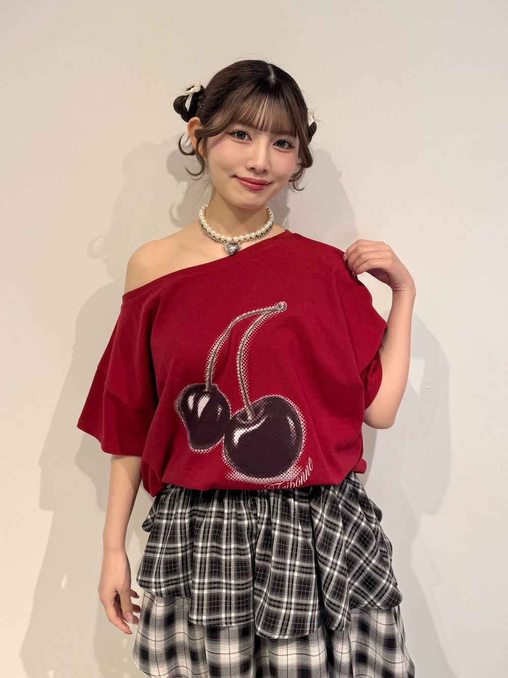 レッド系のTシャツ/カットソー、ブラック系のスカート、ブラック系のブーツを着用したレディースの春コーディネートの5枚目の写真