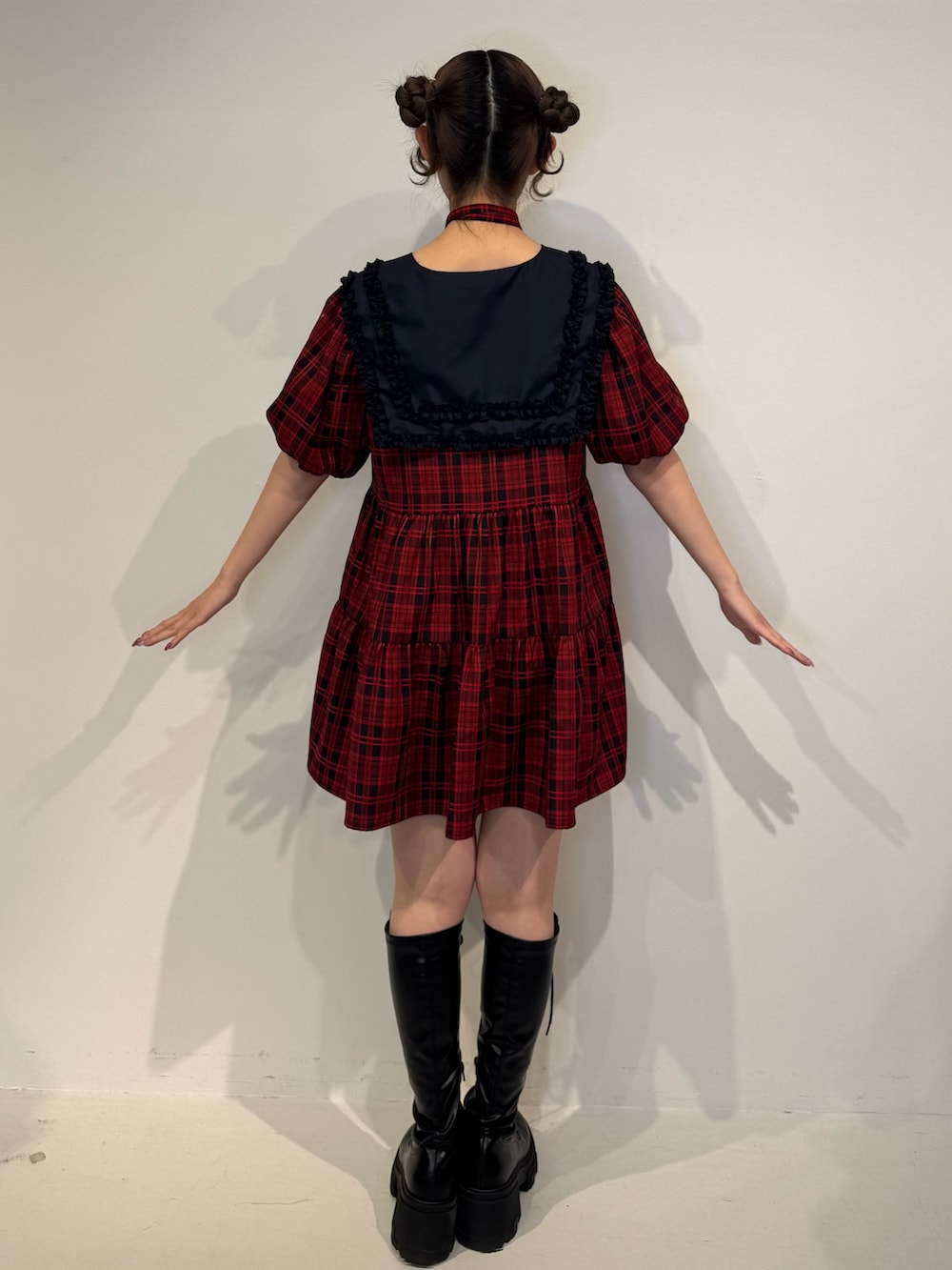 レッド系のワンピース、ブラック系のブーツを着用したレディースの冬コーディネートの4枚目の写真