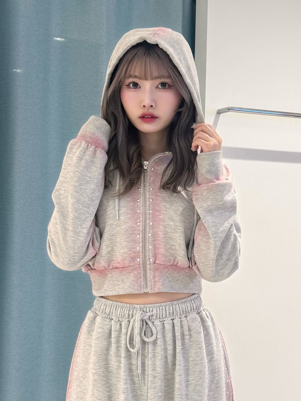 グレー系のパーカー、グレー系のスウェットパンツ、ブラック系のローファーを着用したレディースの春コーディネートの5枚目の写真