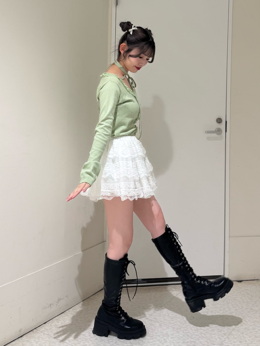 グリーン系のニット/セーター、ホワイト系のその他パンツ、ブラック系のブーツを着用したレディースの冬コーディネートの2枚目の写真