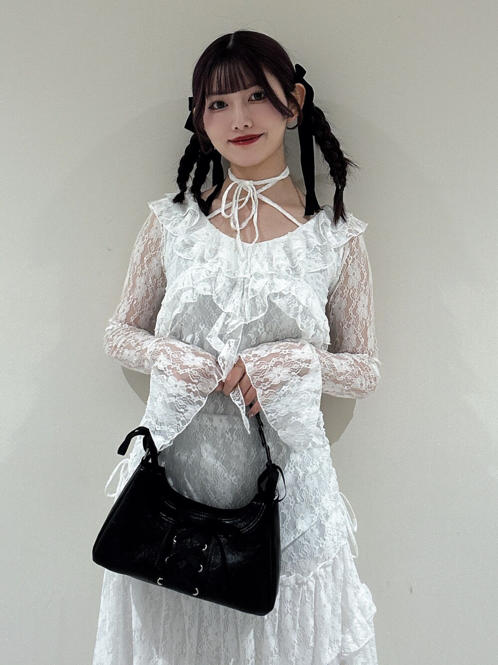 ホワイト系のワンピース、ブラック系のハンドバッグ、ブラック系のパンプスを着用したレディースの冬コーディネートの4枚目の写真