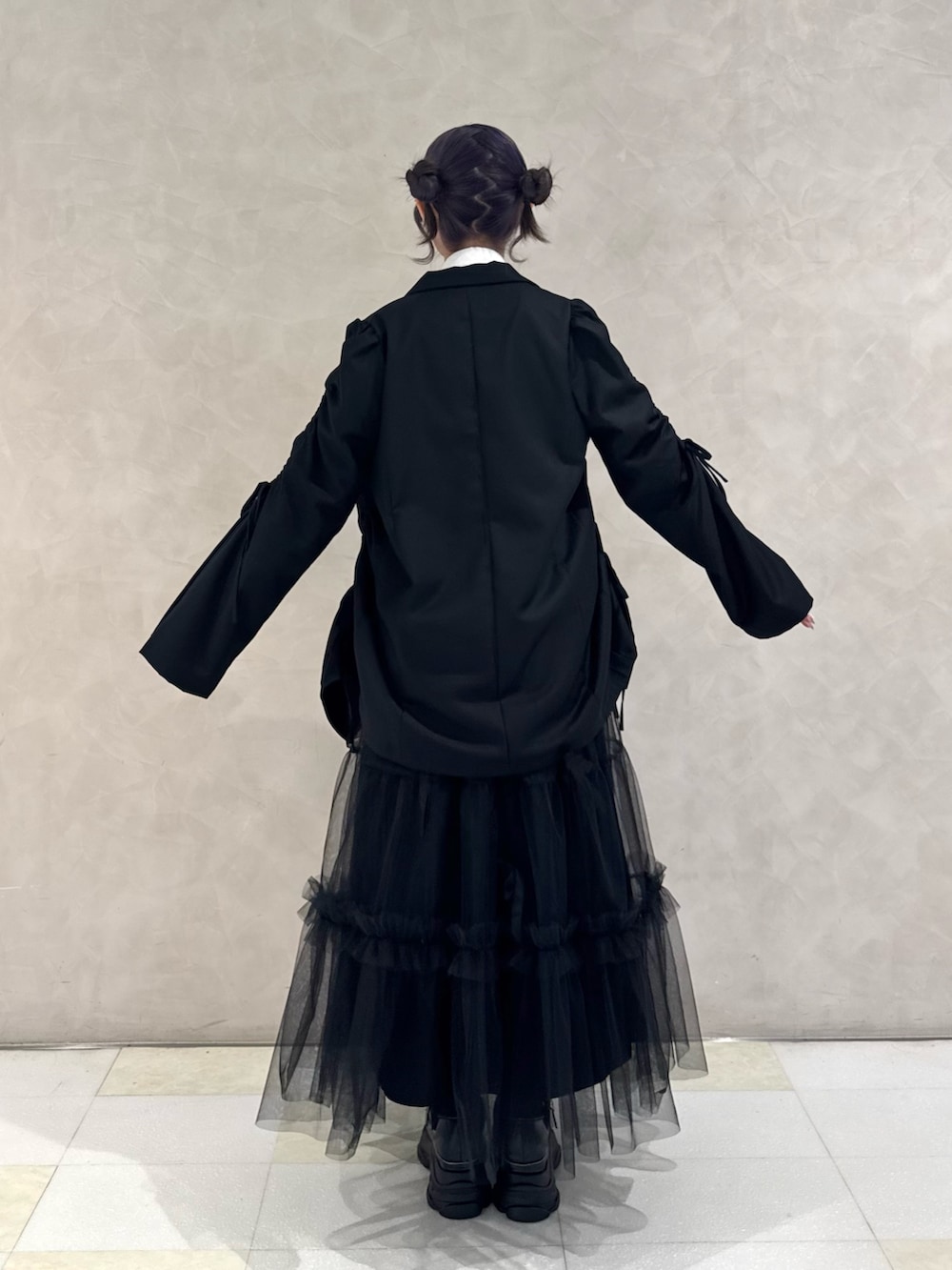 ブラック系のテーラードジャケット、ホワイト系のシャツ/ブラウス、ブラック系のネクタイを着用したレディースの秋コーディネートの3枚目の写真