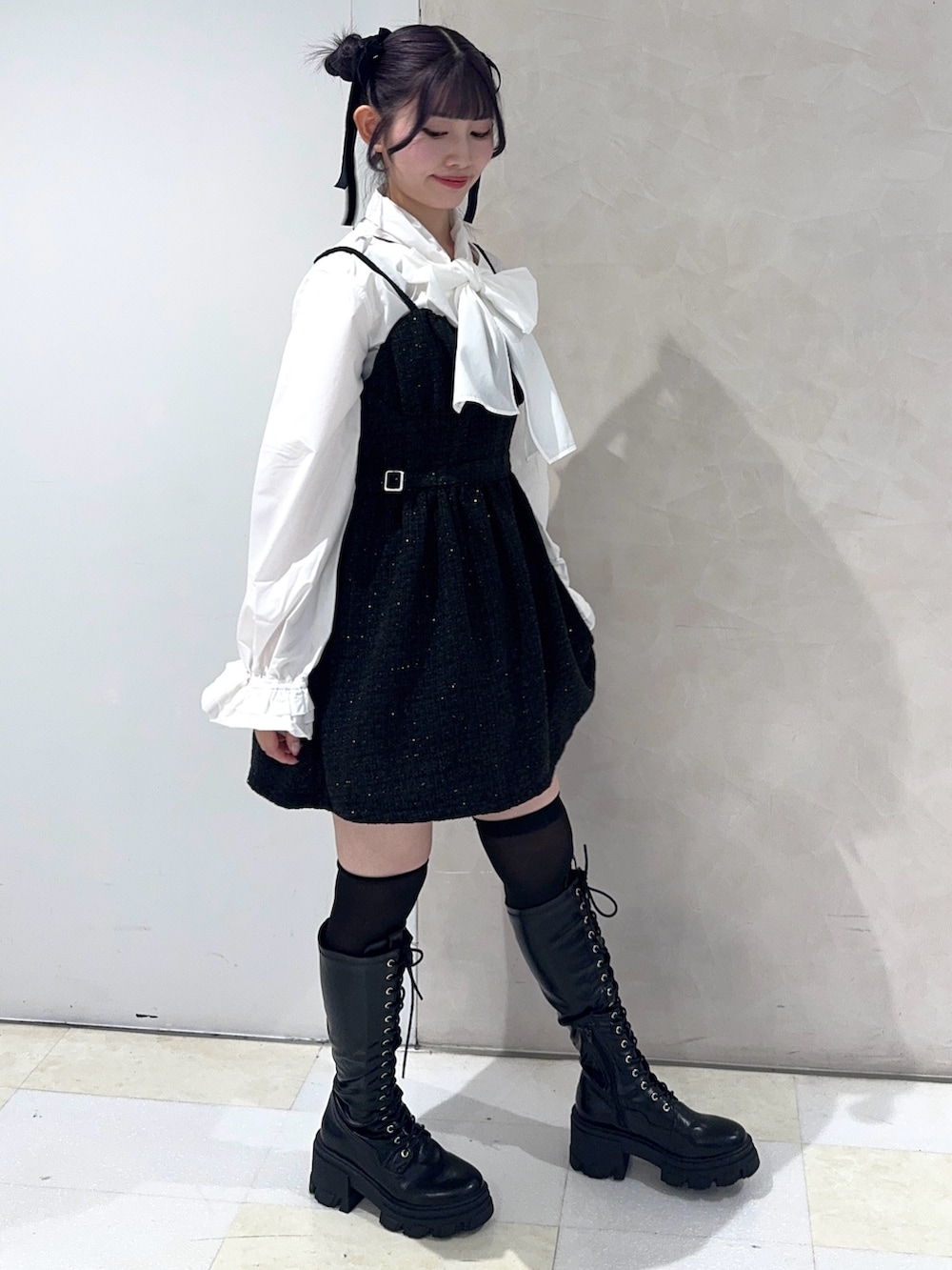 ホワイト系のシャツ/ブラウス、ブラック系のワンピース、ブラック系のブーツを着用したレディースの秋コーディネートの2枚目の写真