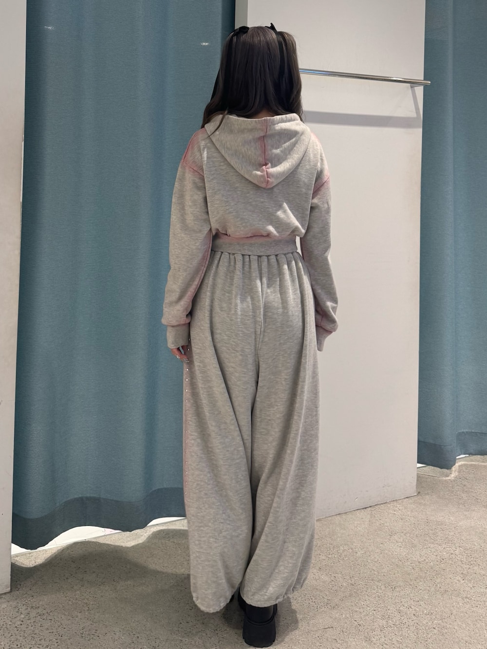 グレー系のパーカー、グレー系のスウェットパンツ、ブラック系のローファーを着用したレディースの春コーディネートの4枚目の写真