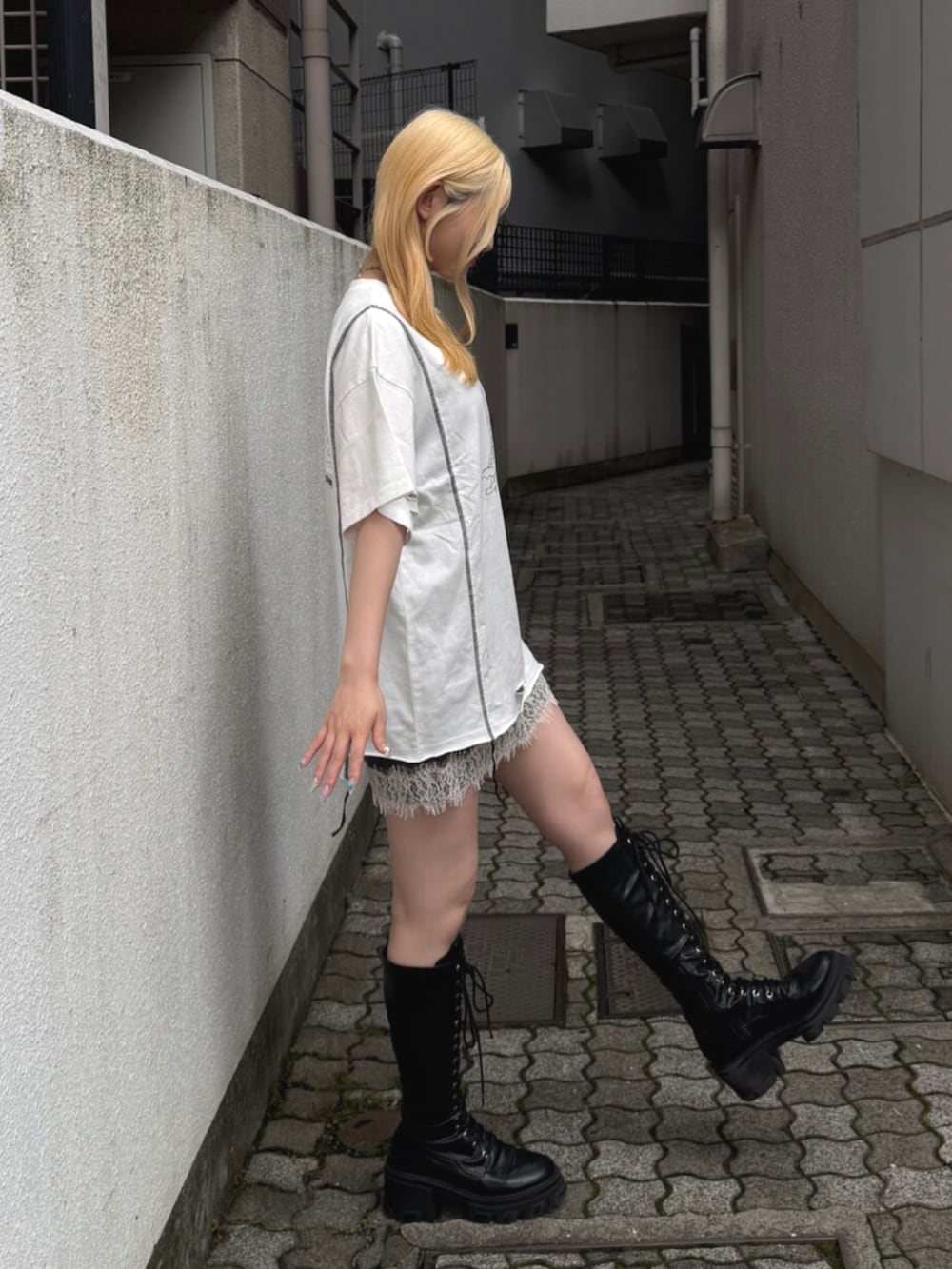 ブラック系のブーツ、ホワイト系のTシャツ/カットソー、ブラック系のワンピースを着用したレディースの夏コーディネートの3枚目の写真