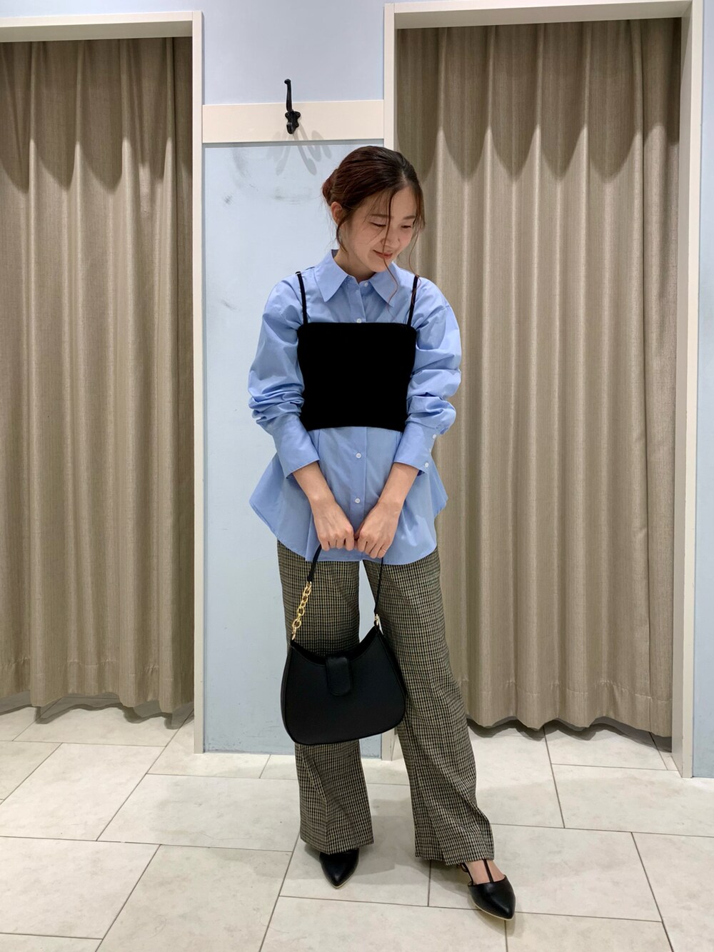 ブルー系のシャツ/ブラウス、ブラック系のニット/セーター、ブラウン系のその他パンツを着用したレディースの秋コーディネートの2枚目の写真