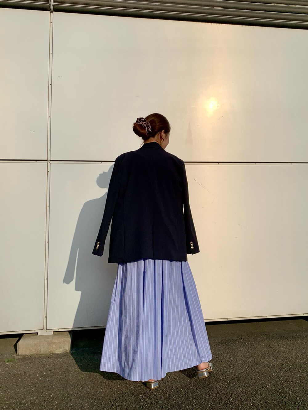 ホワイト系のニット/セーター、ブラウン系のハンドバッグ、ブルー系のスカートを着用したレディースの春コーディネートの4枚目の写真