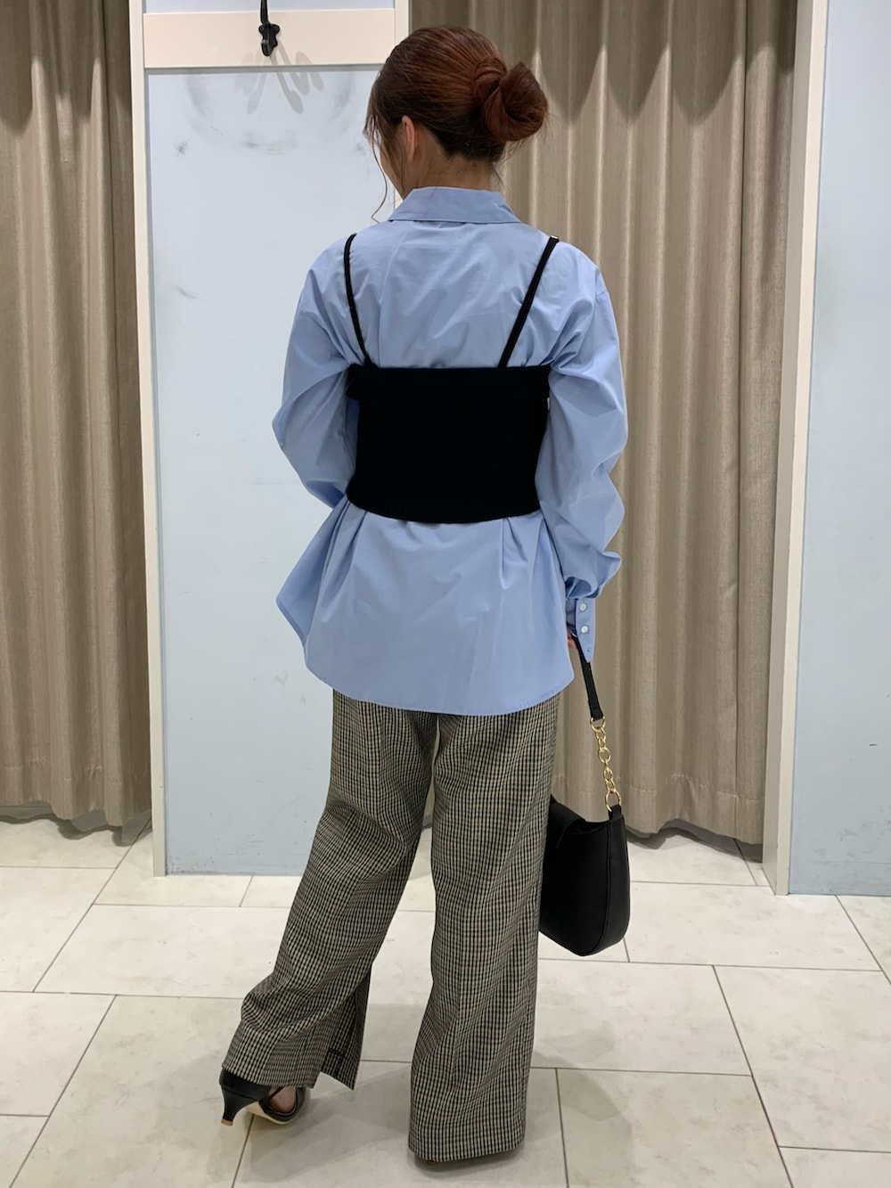 ブルー系のシャツ/ブラウス、ブラック系のニット/セーター、ブラウン系のその他パンツを着用したレディースの秋コーディネートの3枚目の写真