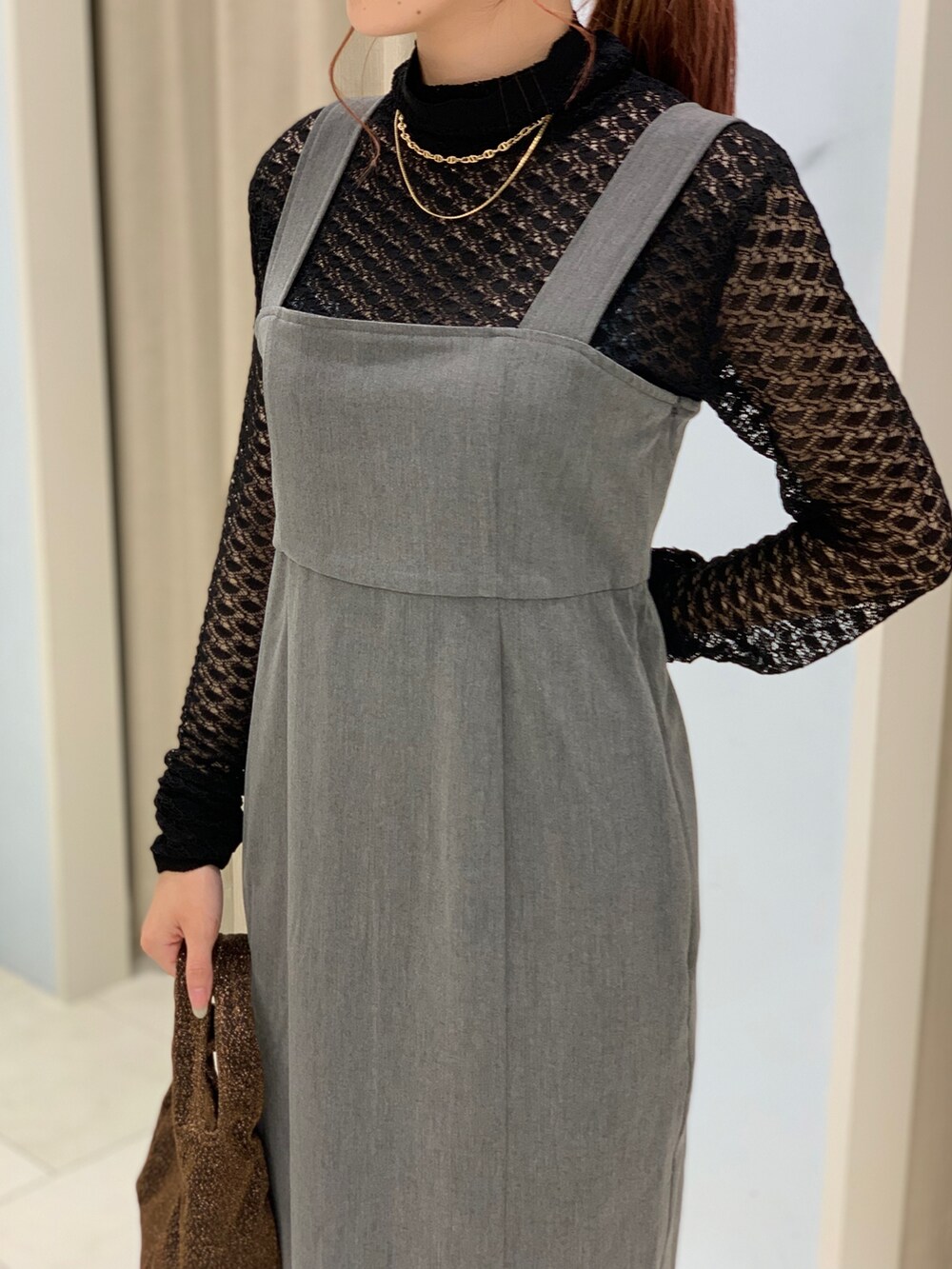 ブラック系のニット/セーター、グレー系のワンピース、ブラック系のパンプスを着用したレディースの秋コーディネートの3枚目の写真