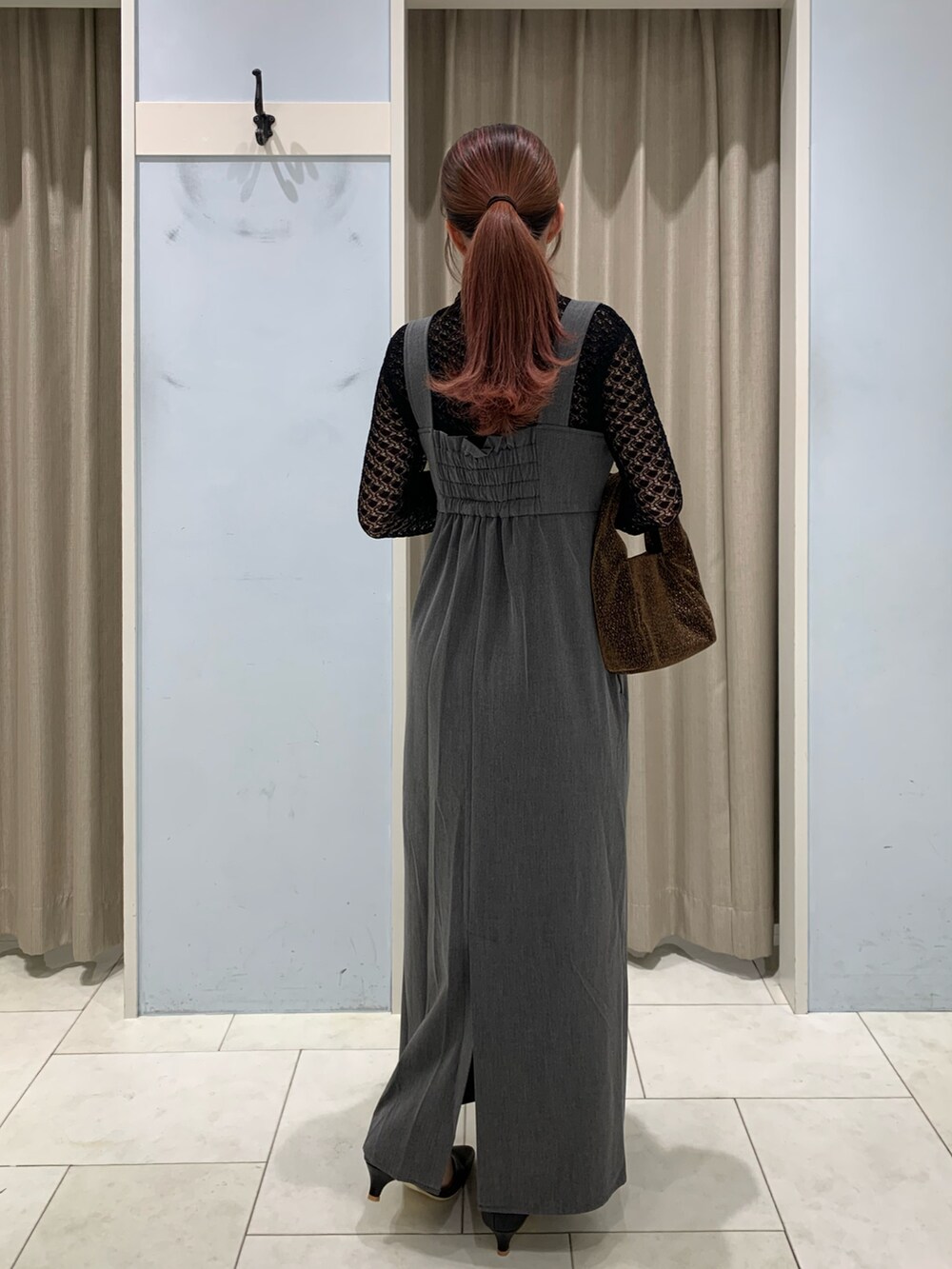 ブラック系のニット/セーター、グレー系のワンピース、ブラック系のパンプスを着用したレディースの秋コーディネートの2枚目の写真