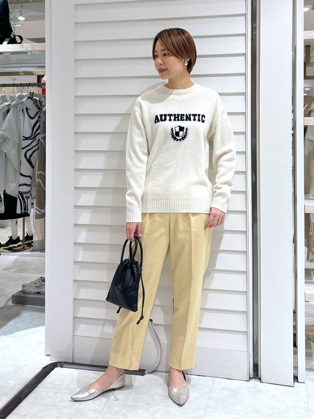 ブラック系のショルダーバッグ、イエロー系のその他パンツ、ホワイト系のニット/セーターを着用したレディースの冬コーディネートの2枚目の写真