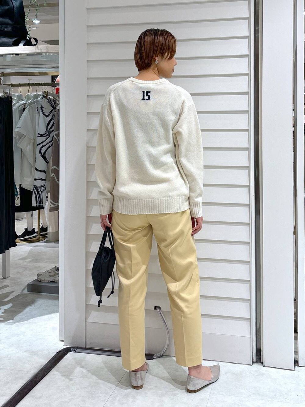 ブラック系のショルダーバッグ、イエロー系のその他パンツ、ホワイト系のニット/セーターを着用したレディースの冬コーディネートの4枚目の写真