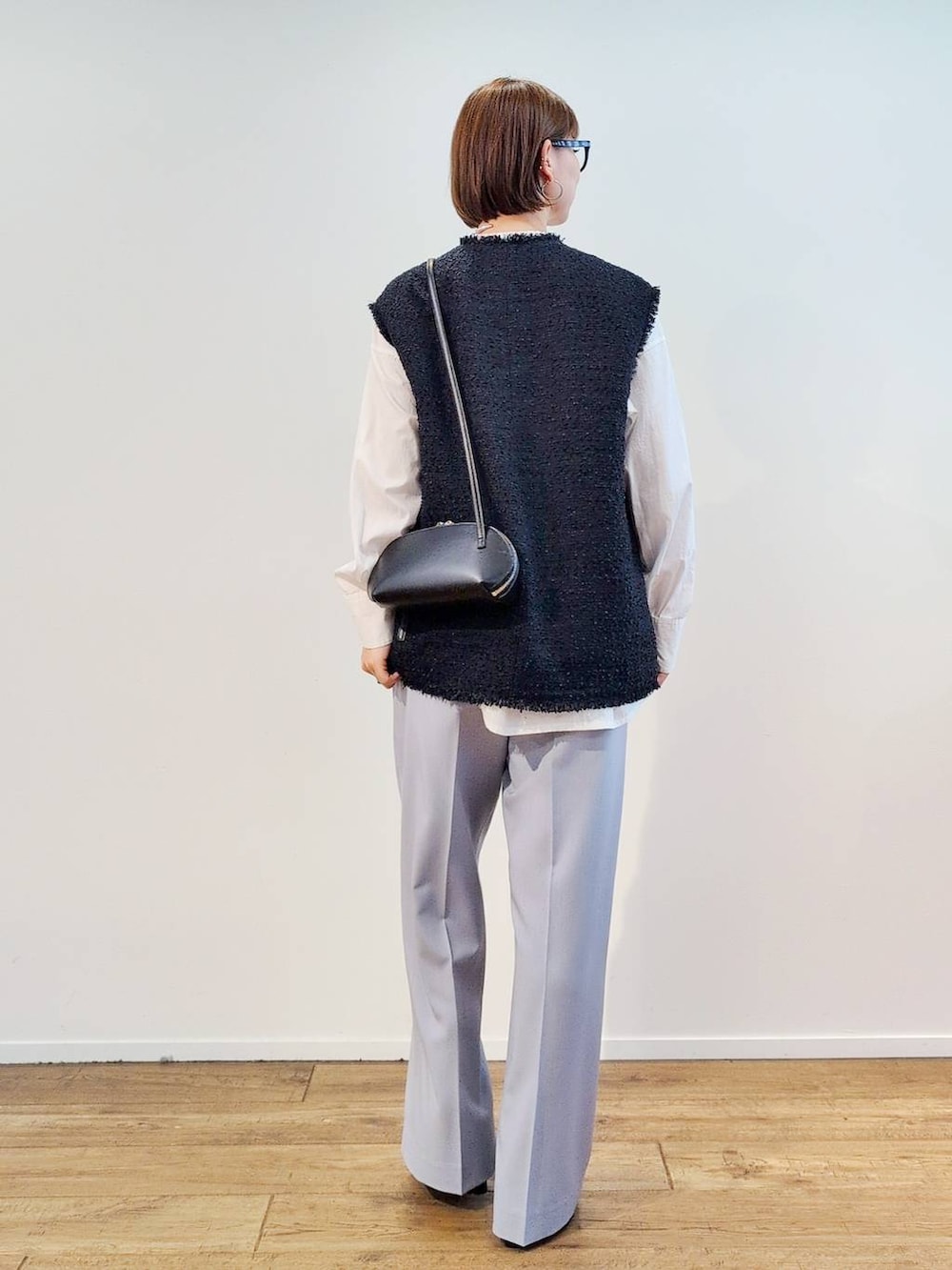 ブラック系のショルダーバッグ、ブラック系のブーツ、ホワイト系のシャツ/ブラウスを着用したレディースの冬コーディネートの8枚目の写真