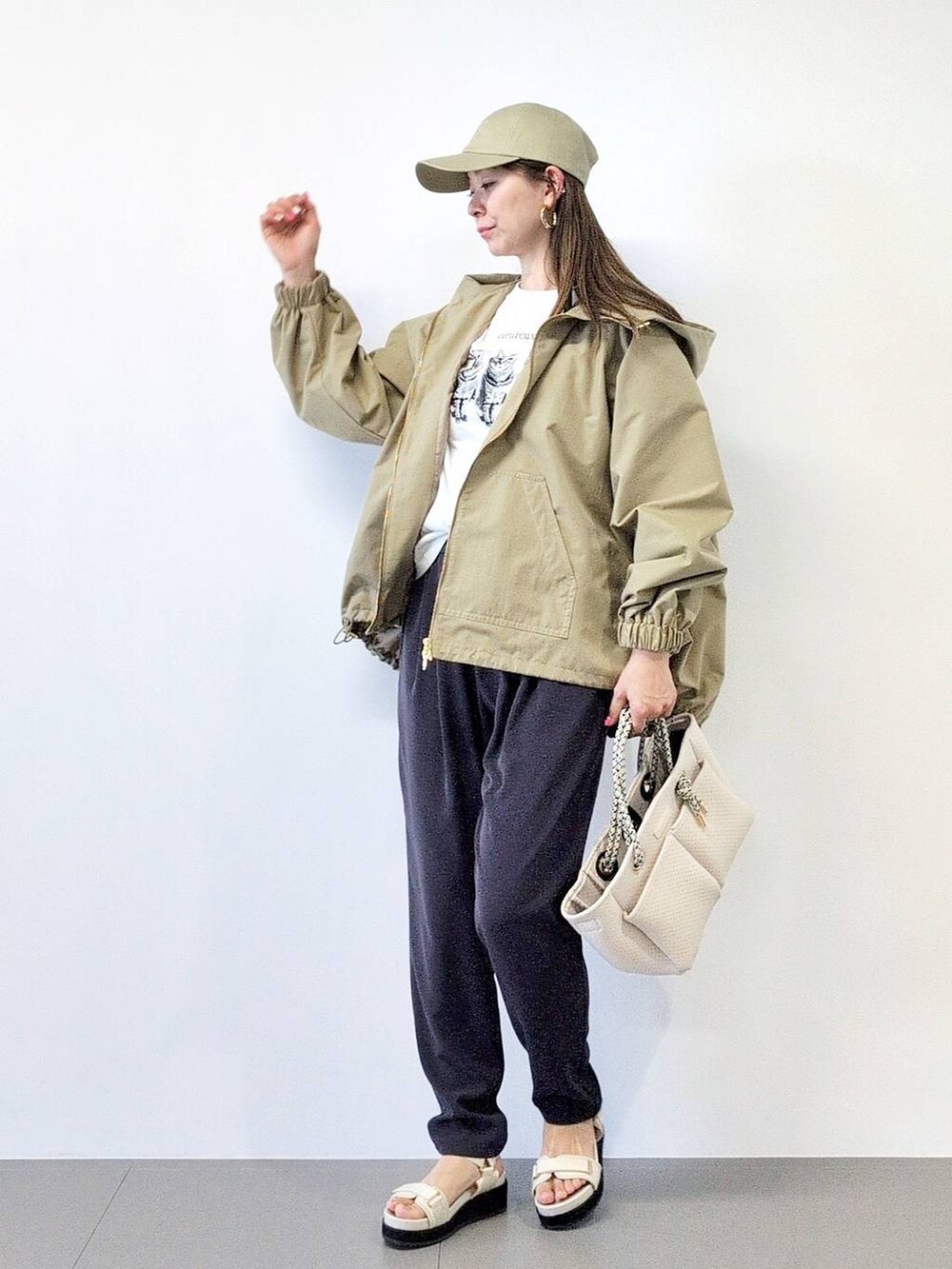 ホワイト系のトートバッグ、ブラック系のスラックス、ベージュ系のブルゾンを着用したレディースの冬コーディネートの3枚目の写真