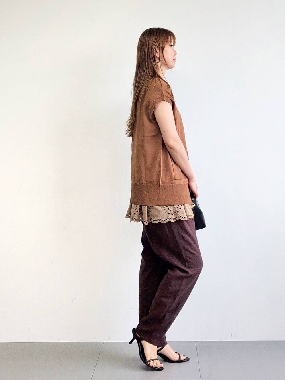 ブラック系のサンダル、ブラウン系のその他パンツ、イエロー系のニット/セーターを着用したレディースの夏コーディネートの4枚目の写真