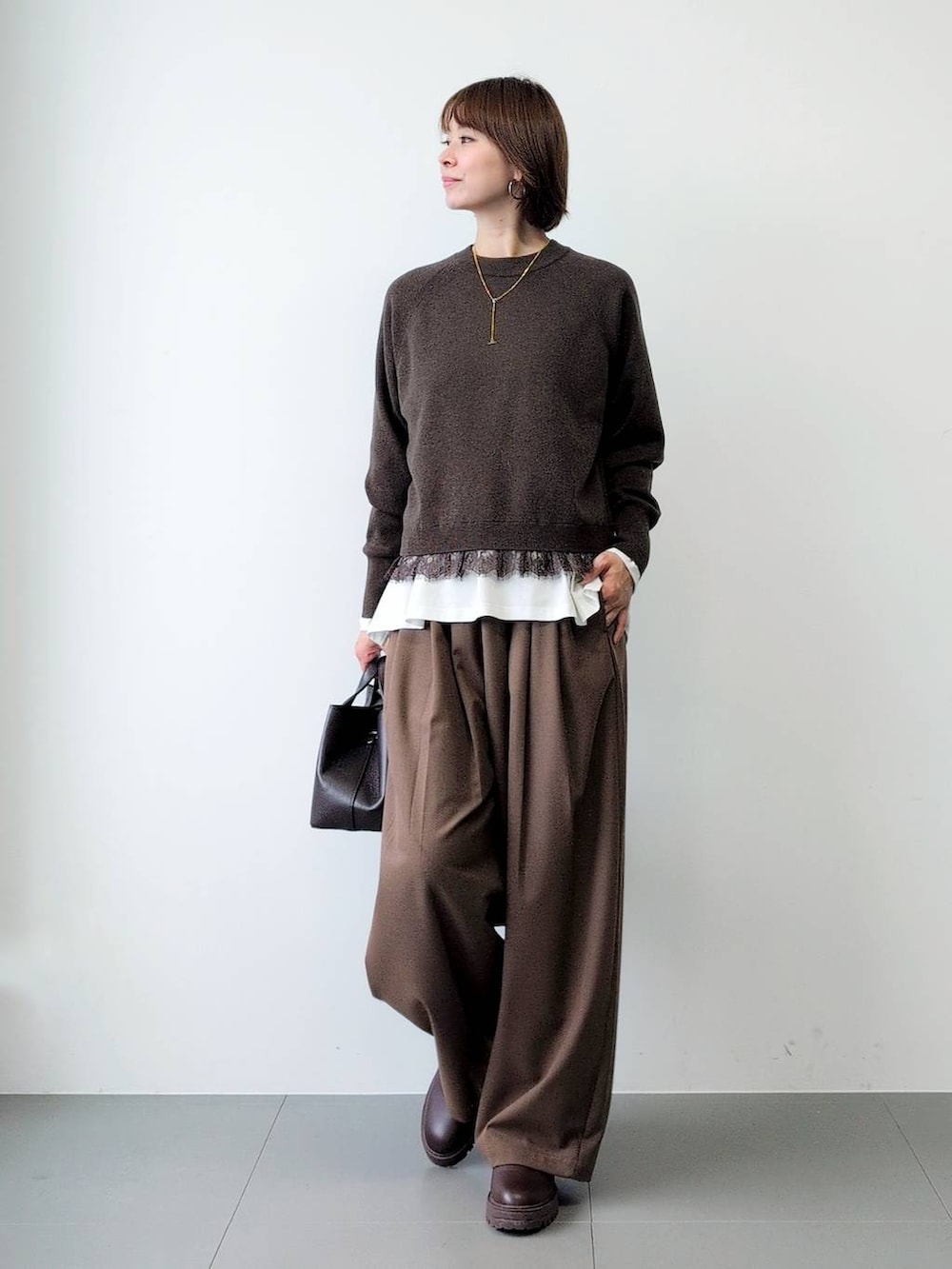 ブラウン系のブーツ、ブラウン系のショルダーバッグ、ブラウン系のその他パンツを着用したレディースの秋コーディネートの6枚目の写真