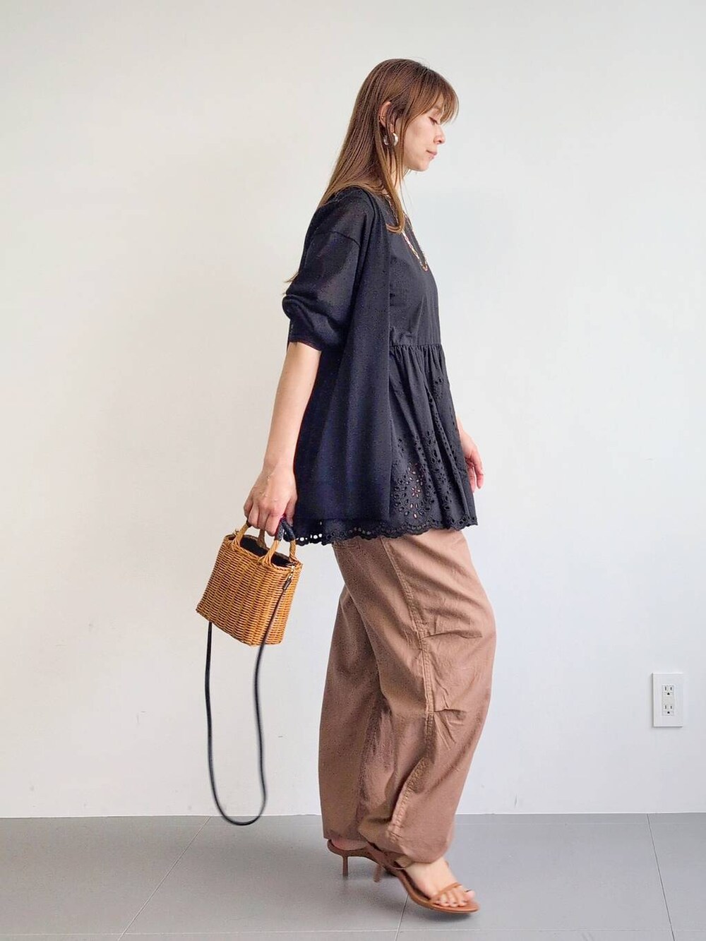 イエロー系のカーゴパンツ、ブラック系のショルダーバッグ、ブラウン系のサンダルを着用したレディースの夏コーディネートの5枚目の写真