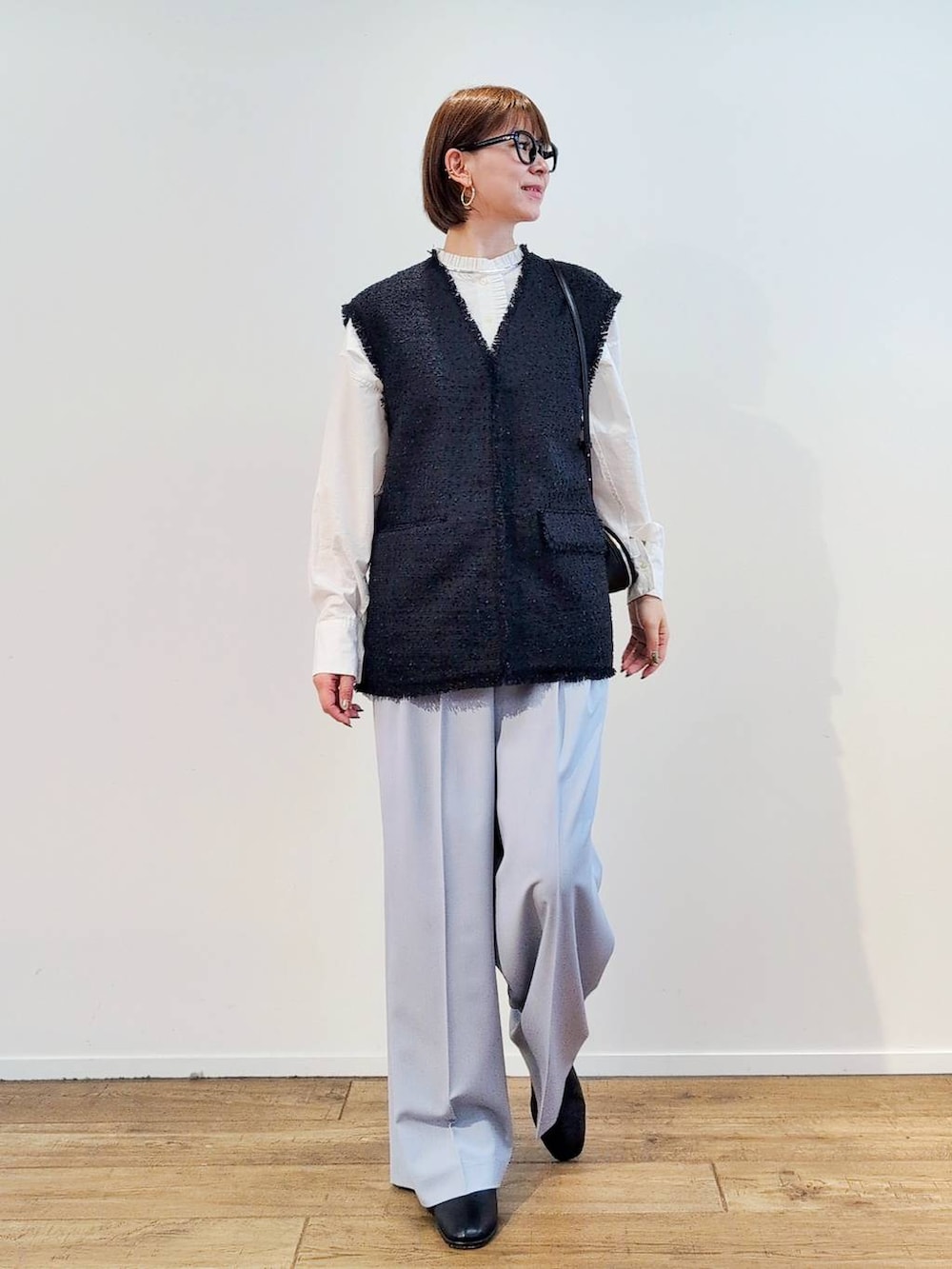 ブラック系のショルダーバッグ、ブラック系のブーツ、ホワイト系のシャツ/ブラウスを着用したレディースの冬コーディネートの2枚目の写真