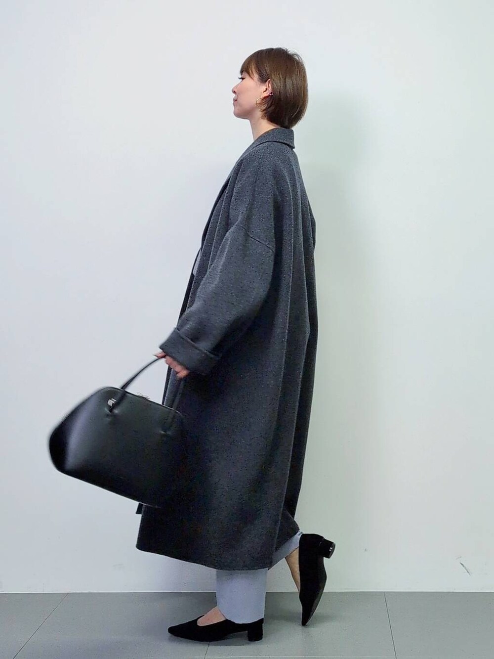 ブラック系のトートバッグ、グレー系のチェスターコート、ブラック系のパンプスを着用したレディースの秋コーディネートの6枚目の写真