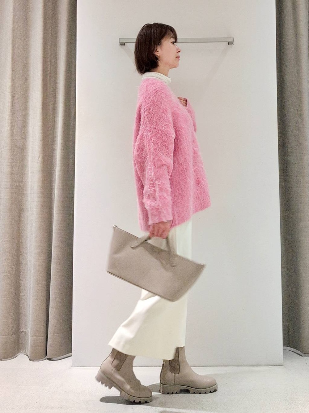 ホワイト系のTシャツ/カットソー、ベージュ系のピーコート、ホワイト系のスカートを着用したレディースの秋コーディネートの7枚目の写真