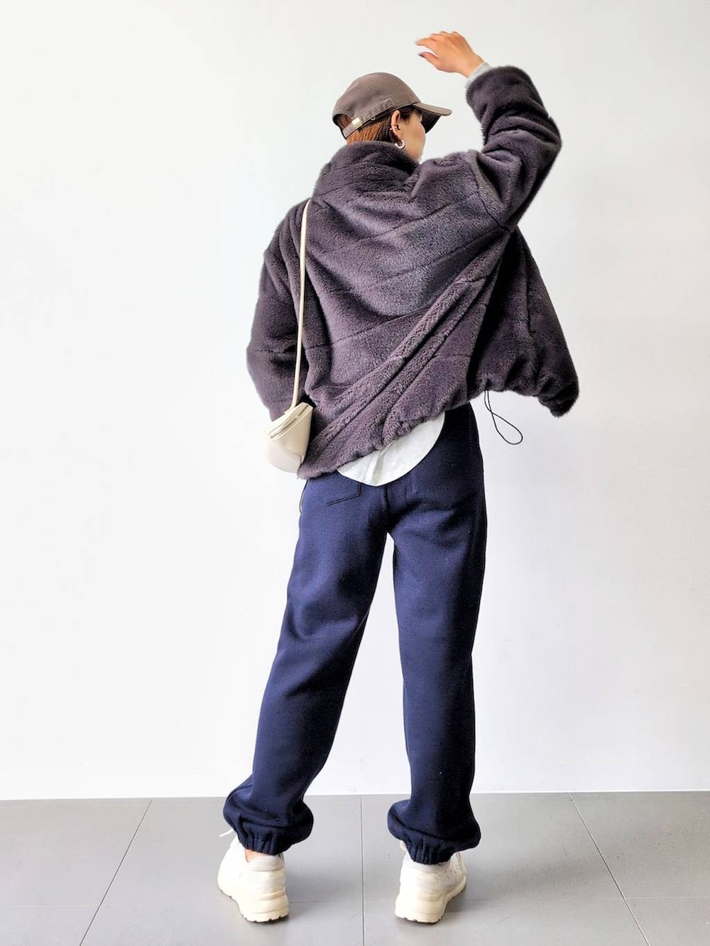 ホワイト系のショルダーバッグ、グレー系のブルゾン、ホワイト系のスニーカーを着用したレディースの秋コーディネートの8枚目の写真