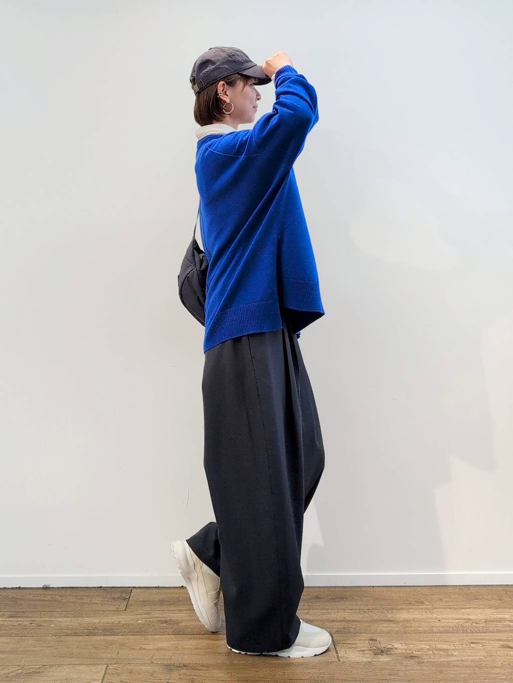 グレー系のボディバッグ/ウエストポーチ、ホワイト系のTシャツ/カットソー、グレー系のスラックスを着用したレディースの秋コーディネートの5枚目の写真