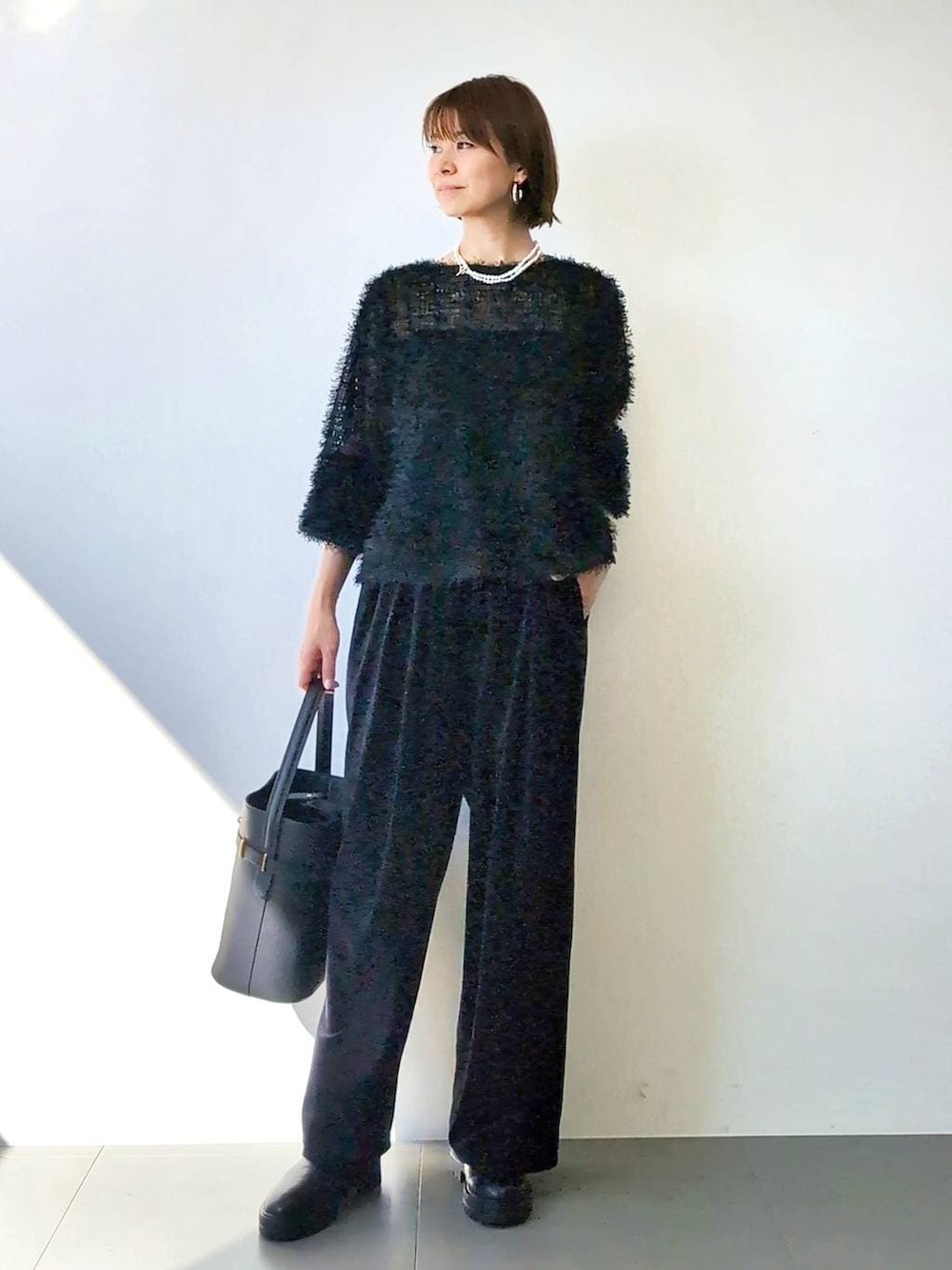 ブラック系のブーツ、ブラック系のハンドバッグ、ブラック系のキャミソールを着用したレディースの冬コーディネートの3枚目の写真