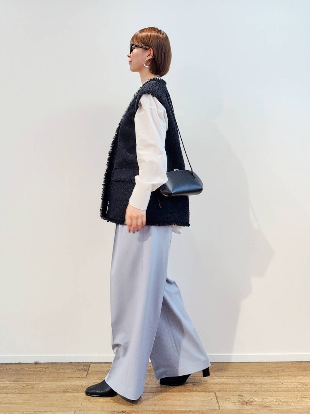 ブラック系のショルダーバッグ、ブラック系のブーツ、ホワイト系のシャツ/ブラウスを着用したレディースの冬コーディネートの6枚目の写真