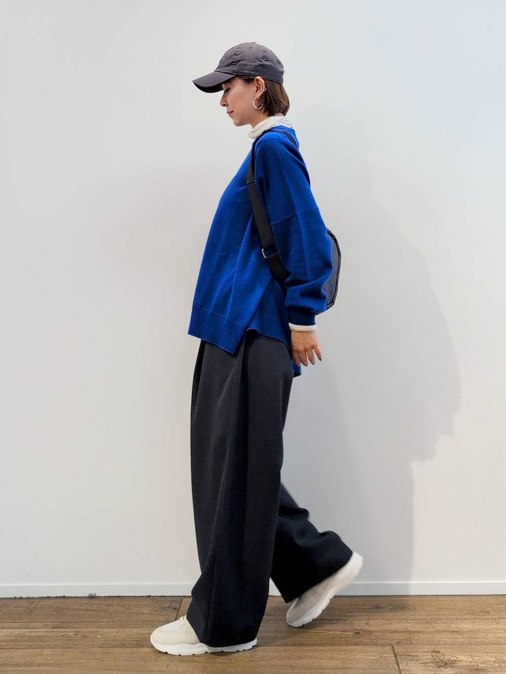 グレー系のボディバッグ/ウエストポーチ、ホワイト系のTシャツ/カットソー、グレー系のスラックスを着用したレディースの秋コーディネートの6枚目の写真