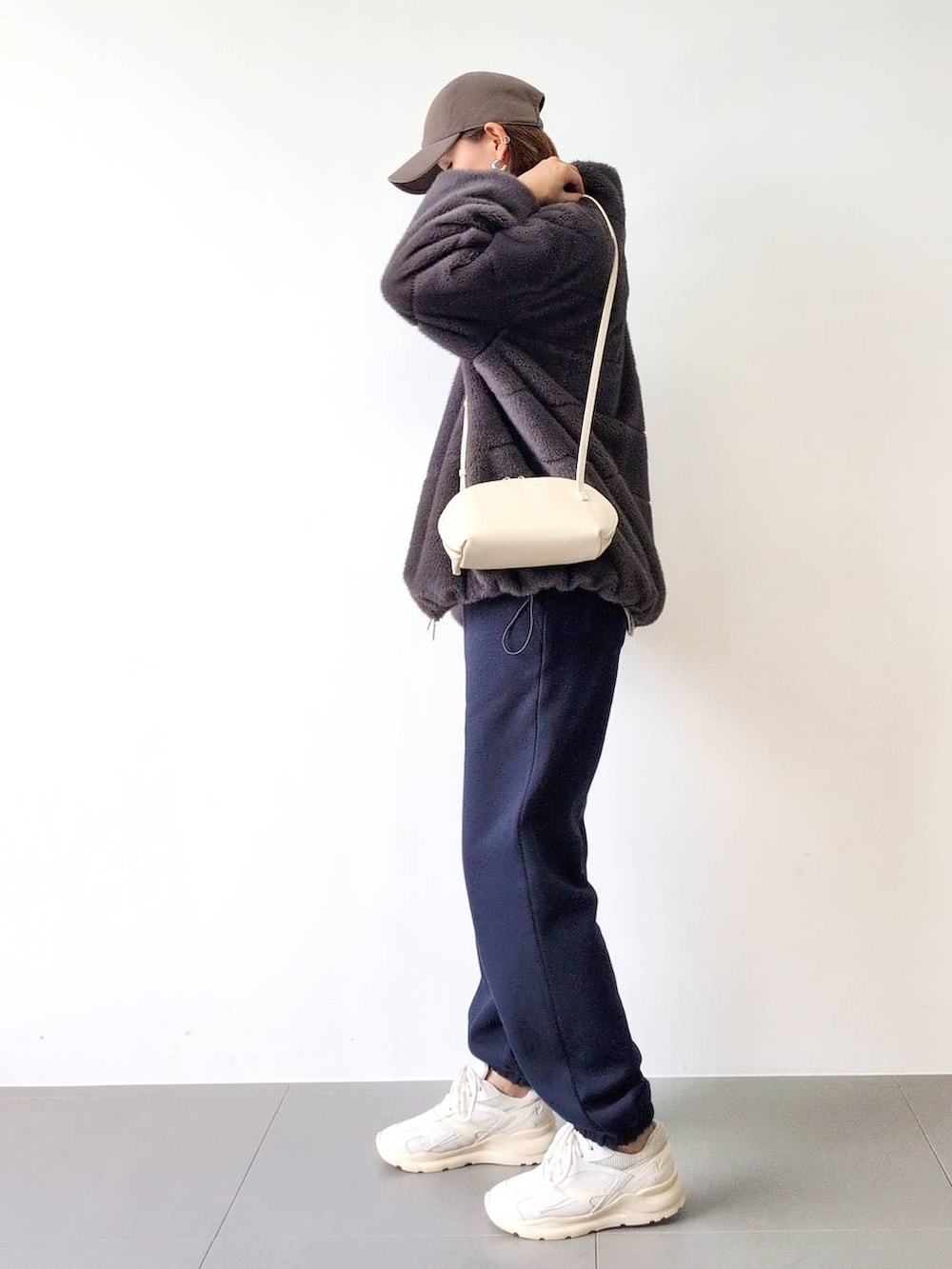 ホワイト系のショルダーバッグ、グレー系のブルゾン、ホワイト系のスニーカーを着用したレディースの秋コーディネートの5枚目の写真