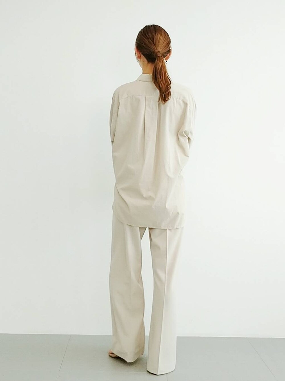 ベージュ系のスリッポン、ベージュ系のスラックス、その他のチョーカーを着用したレディースの夏コーディネートの5枚目の写真