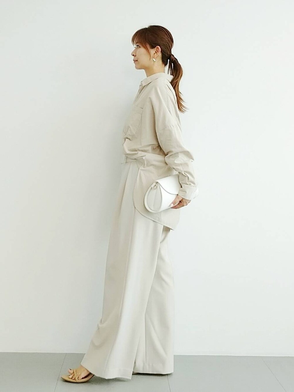 ベージュ系のスリッポン、ベージュ系のスラックス、その他のチョーカーを着用したレディースの夏コーディネートの3枚目の写真