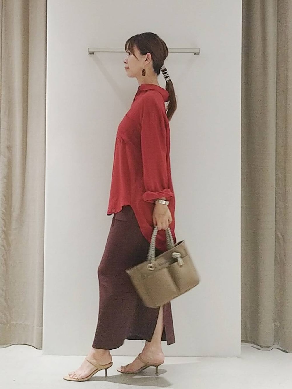 ベージュ系のスリッポン、ブラウン系のトートバッグ、レッド系のシャツ/ブラウスを着用したレディースの夏コーディネートの3枚目の写真