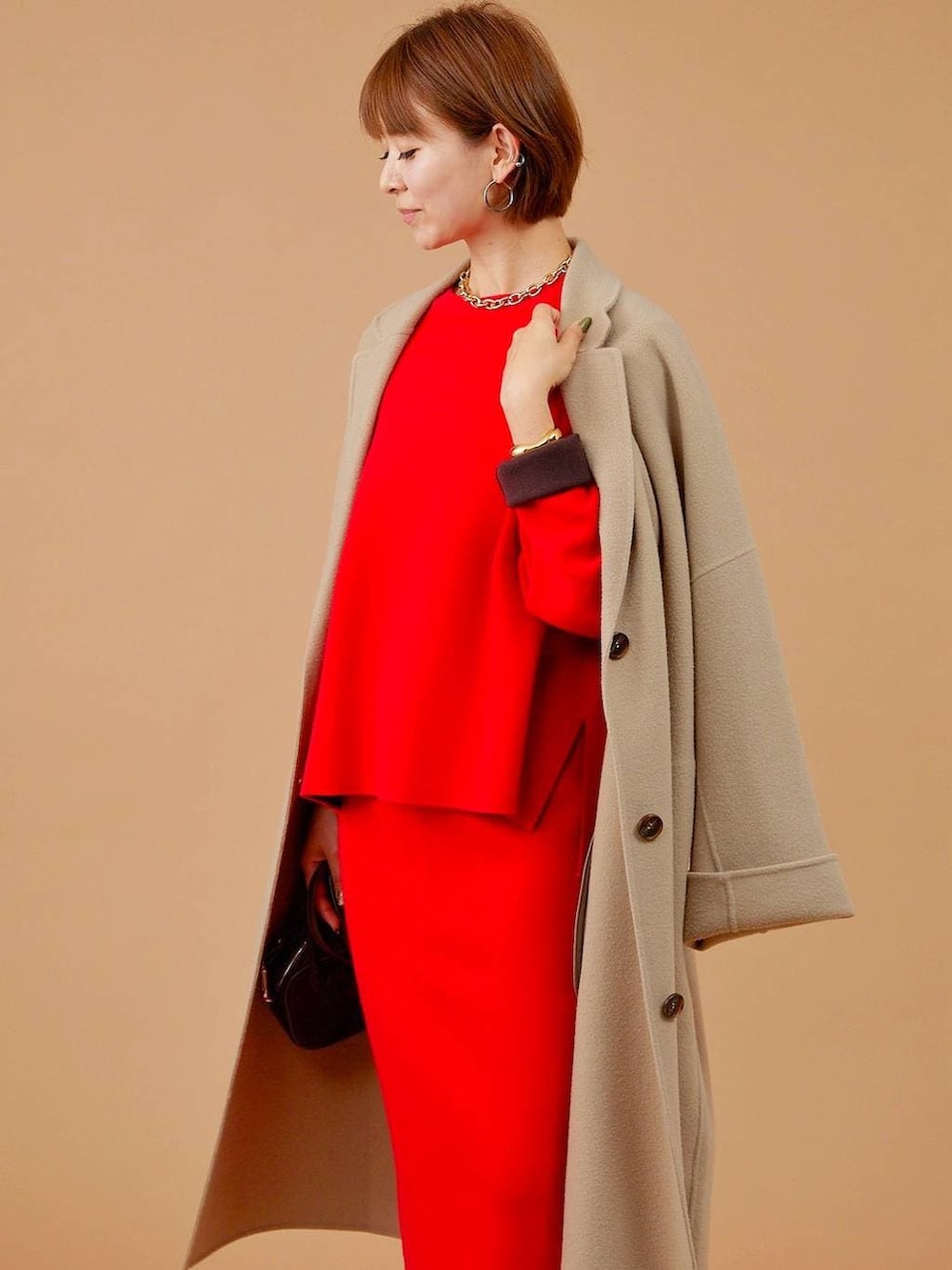 ベージュ系のチェスターコート、ブラウン系のショルダーバッグ、ブラウン系のブーツを着用したレディースの冬コーディネートの7枚目の写真